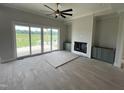 Open living room with a fireplace, cabinets, and sliding glass doors to the backyard at 4905 Hidden Pasture Way, Zebulon, NC 27597