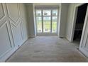 Bright living room featuring decorative wall trim and large windows overlooking lush greenery at 4905 Hidden Pasture Way, Zebulon, NC 27597