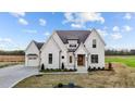 New traditional-style home featuring a manicured lawn, a three car garage, and a covered front porch at 4909 Hidden Pasture Way, Zebulon, NC 27597