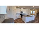 Modern kitchen with white cabinets, granite countertops, and an island at 829 Emmer St, Rolesville, NC 27571
