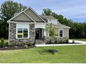 Charming single-Gathering home with stone accents, manicured lawn, and an 'available' sign at 69 Browning Mill Dr, Wendell, NC 27591