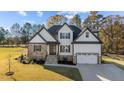 Beautiful two-story home featuring stone accents, white siding, and a well-manicured lawn at 148 Hook Dr # 7, Fuquay Varina, NC 27526