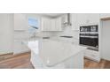 Close-up of the kitchen with an island, white cabinets, subway tile backsplash, and gas range at 305 Chestnut Oak Ln, Lillington, NC 27546