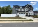 A two-story home with a two-car garage and a white fence surrounding the property at 9113 Dupree Meadow Dr # 41, Angier, NC 27501