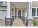 Inviting front entry with stone pillars and a black front door at 9113 Dupree Meadow Dr # 41, Angier, NC 27501