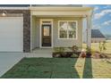 Inviting front porch with manicured lawn and garden adjacent to an attached garage at 32 Furley St., Homesite 53, Sanford, NC 27330