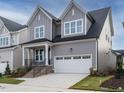 Charming gray two-story home with attached two car garage and well-manicured front lawn at 1721 Grassy Falls Ln, Wendell, NC 27591