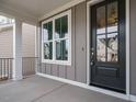 Inviting covered front porch with a modern black front door and bright window at 1721 Grassy Falls Ln, Wendell, NC 27591