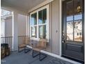 Cozy front porch with seating and stylish decor by a black front door and bright window at 1721 Grassy Falls Ln, Wendell, NC 27591