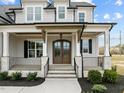 Welcoming front porch with stone accents, a double door entry, and iron railings at 110 Summerlin Dr, Clayton, NC 27527