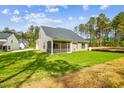 View of the back of the house with a screened-in porch and a lush green lawn at 73 Artic Cir, Garner, NC 27529
