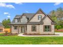 Attractive brick home with dark trim, manicured lawn, and a sidewalk leading to the covered entry at 3402 St Barts Pl, Mebane, NC 27302