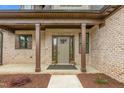 Inviting front porch with brick columns and a welcoming front door with decorative plantings at 3402 St Barts Pl, Mebane, NC 27302