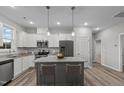 Bright kitchen features stainless steel appliances, gray cabinets and a granite island with bar stool seating at 125 Brookhaven Dr, Spring Hope, NC 27882