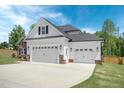Three-car garage with white doors and stone accents at 21 Walnut Hall Ct, Selma, NC 27576