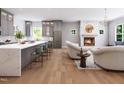 Open-concept living space showcasing a modern kitchen, fireplace, and comfortable seating area with wood flooring at 154 Colonial Trail Ct, Pittsboro, NC 27312
