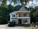 Two-story home featuring a covered porch with wooden railings and visible construction debris at 8305 Society Pl, Raleigh, NC 27615