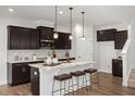 Modern kitchen showcasing a center island, dark cabinetry, and stainless steel appliances at 176 Van Winkle St, Lillington, NC 27546