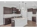 Modern kitchen boasts dark wood cabinets, granite countertops, and stainless steel appliances at 176 Van Winkle St, Lillington, NC 27546
