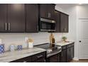 Close up of the kitchen, with stainless steel appliances and tile backsplash at 176 Van Winkle St, Lillington, NC 27546