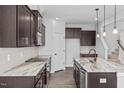 Open kitchen with dark cabinets, granite countertops, an island, and stainless steel appliances at 176 Van Winkle St, Lillington, NC 27546