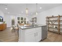 Modern eat-in kitchen with stainless dishwasher and large island, flowing into a cozy living space at 4015 Elk Creek Ln, Raleigh, NC 27612