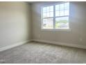 Bright bedroom offers plush carpeting, neutral walls, and a large window providing ample natural light at 592 Barbour Farm Ln, Four Oaks, NC 27524