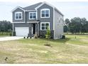 Attractive two-story home with gray siding, stone accents, and a pristine lawn in a desirable location at 592 Barbour Farm Ln, Four Oaks, NC 27524
