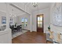 Bright entryway with hardwood floors, an elegant chandelier, and a view to the dining room at 130 Summerlin Dr, Clayton, NC 27527