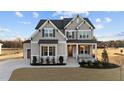 Two-story home with gray siding, landscaped yard, and a three-car garage at 130 Summerlin Dr, Clayton, NC 27527