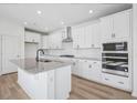 Modern kitchen with white cabinets, granite counters, and island at 234 Chestnut Oak Ln, Lillington, NC 27546