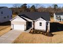 New construction home showcasing a two-car garage and landscaped yard at 411 Fast Pitch Ln, Four Oaks, NC 27524