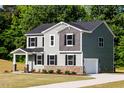 Beautiful two-story home featuring a lush green lawn, stone accents, and an attached garage at 427 Fast Pitch Ln, Four Oaks, NC 27524