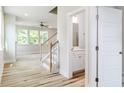 Bright foyer with hardwood floors, an open staircase, and a view into the living area at 427 Fast Pitch Ln, Four Oaks, NC 27524