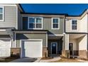 Charming townhome showcasing a two-car garage, a black front door, and multiple windows at 565 Marthas View Way, Wake Forest, NC 27587