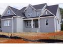 Newly constructed two-story home featuring gray brick, a covered porch, and a dark roof at 2909 Frances Marie Ln, Raleigh, NC 27603