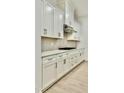 A close-up view of the kitchen, which features modern appliances, wooden floors, and white cabinets at 2048 Abbeyhill Dr # 98, Raleigh, NC 27610