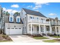 Charming two-story home with a welcoming front porch and balcony, complemented by lush landscaping at 809 St Charles St, Durham, NC 27713