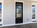 Close up view of a craftsman-style front door with glass panels and sidelights at 809 St Charles St, Durham, NC 27713