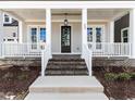 Inviting front porch with brick stairs, white railings, and craftsman style door at 809 St Charles St, Durham, NC 27713