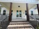 Welcoming front porch featuring beautiful dark wooden pillars and black metal handrails at 30 Tamaran Ct, Spring Hope, NC 27882