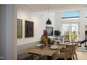 Bright dining room with modern lighting, sleek black television, and access to outdoor deck at 106 Broadway St # 202, Durham, NC 27701