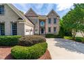 Two-story brick home with a three-car garage and manicured landscaping at 11603 Broadfield Ct, Raleigh, NC 27617
