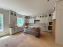 Unfinished kitchen with gray cabinets and island, awaiting final touches at 155 Gaines Trl, Pittsboro, NC 27312