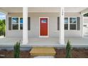 Inviting front porch featuring a bright red door, classic columns, and neat landscaping at 148 Harmony Trl, Broadway, NC 27505