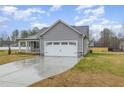 Well-maintained single-story home with gray siding, stone accents, and a two-car garage, set on a spacious lot at 106 Burnello Ct, Princeton, NC 27569