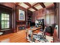 Elegant wood-paneled office featuring custom millwork, a marble fireplace, and a sophisticated executive desk at 1820 Oatlands Court Ct, Wake Forest, NC 27587