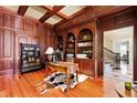 Executive office featuring wood paneled walls, built-in bookshelves, coffered ceiling, and hardwood floors at 1820 Oatlands Court Ct, Wake Forest, NC 27587