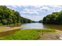 Beautiful water view surrounded by mature trees underneath a partly cloudy sky at 1820 Oatlands Court Ct, Wake Forest, NC 27587