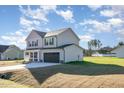 Side view of a two-story home with a two-car garage and freshly sodded lawn at 300 Tuscany Cir, Princeton, NC 27569